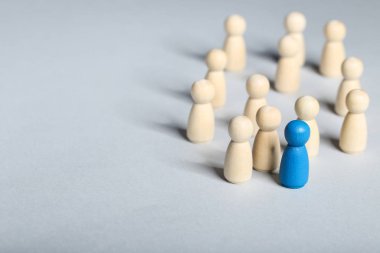 Lider konsepti. Gri arkaplanda tahta figürler