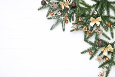 Beyaz ahşap masada oyuncakları olan Noel ağacı dalları