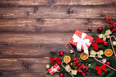 Noel ağacı dalları oyuncaklar ve kahverengi ahşap bir hediye kutusu.