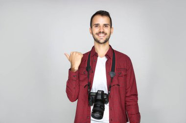 Gri arka planda kameralı genç fotoğrafçı