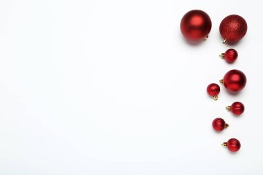 Yılbaşı kompozisyonu düzleştirildi. Beyaz arkaplanda kırmızı takılar