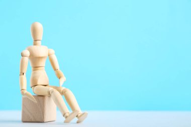 Mavi arkaplanda duran tahta figür