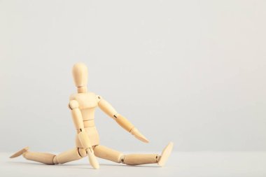 Gri arkaplan üzerinde egzersiz yapan ahşap figür