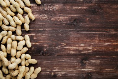 Kahverengi ahşap masada kabuklu fıstıklar