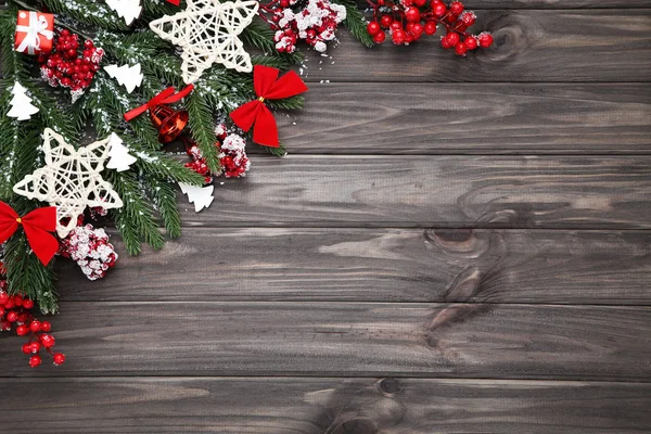 Christmas tree branches with toys and red berries on wooden tabl — Stock Photo, Image