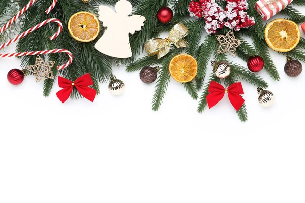 Kerstboom takken met speelgoed en oranje fruit op witte rug — Stockfoto