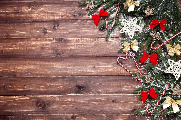 Kerstboom takken met speelgoed en snoepjes op bruin houten ta — Stockfoto