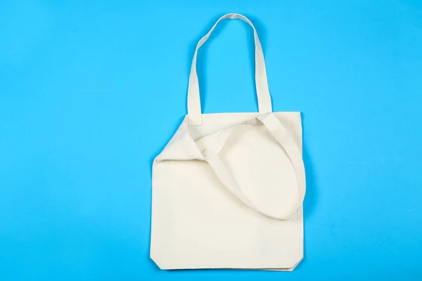 White cotton eco bag on blue background