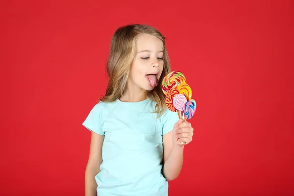 Jong meisje met kleurrijke lolly 's op rode achtergrond — Stockfoto