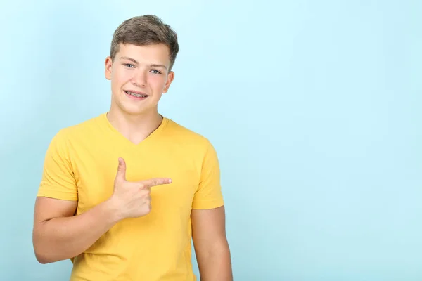 Junger Mann Mit Zahnspange Zeigt Auf Blauem Hintergrund Weg — Stockfoto