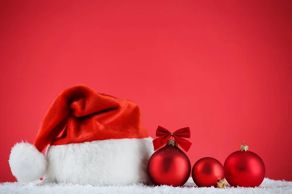Rode Kerstmuts Met Kerstballen Rode Achtergrond — Stockfoto