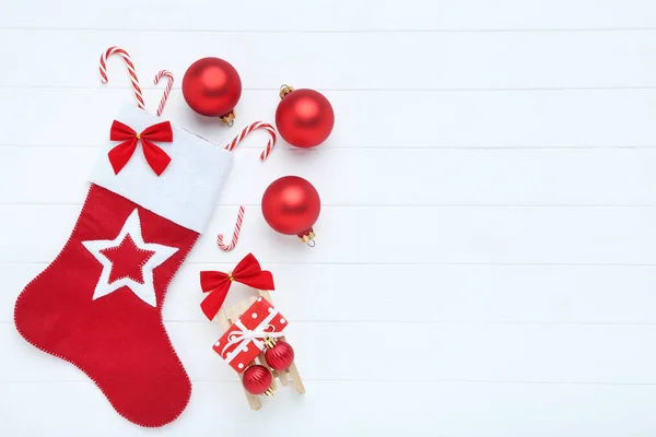 白色木制桌子上有圣诞装饰品的红色长袜 — 图库照片