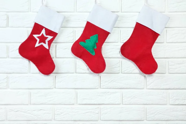 挂在砖墙背景上的红色圣诞长袜 — 图库照片