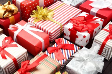 Kahverengi ahşap masada kurdeleli hediye kutuları.