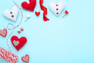 Mandallı kumaş kalpler ve mavi arka planda ip.