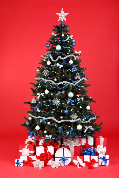 Рождественская Елка Орнаментами Подарочными Коробками Красном Фоне — стоковое фото
