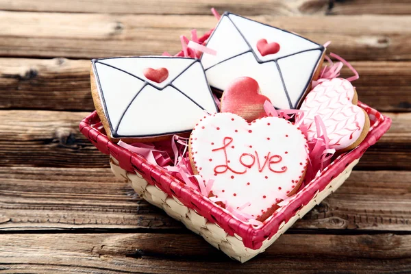 Valentine day cookies in basket on brown wooden table