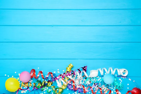 Kolorowe Wstążki Balonami Konfetti Niebieskim Drewnianym Tle — Zdjęcie stockowe