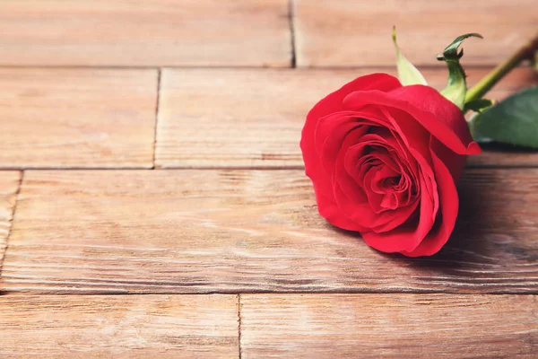 Κόκκινο Τριαντάφυλλο Στο Καφετί Ξύλινο Τραπέζι — Φωτογραφία Αρχείου
