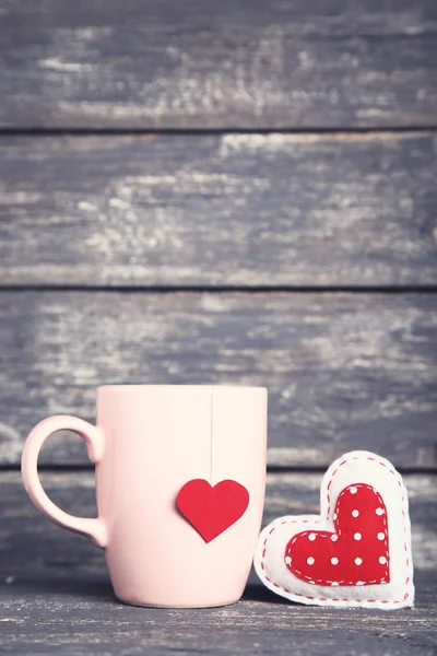 Fabric heart and cup with teabag on grey wooden table