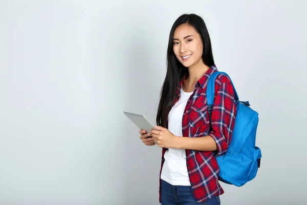 Mulher Bonita Segurando Tablet Mochila Fundo Cinza — Fotografia de Stock