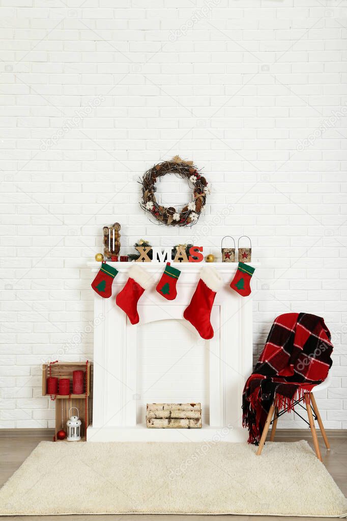 Decorated fireplace for christmas near brick wall at home