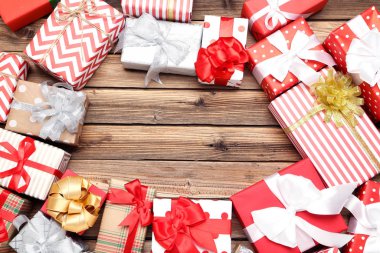 Kahverengi ahşap masada kurdeleli hediye kutuları.