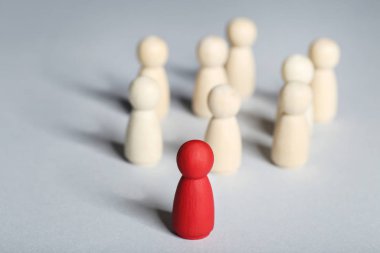 Lider konsepti. Gri arkaplanda tahta figürler