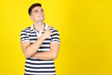 Sarı arka planda gülümseyen genç adam
