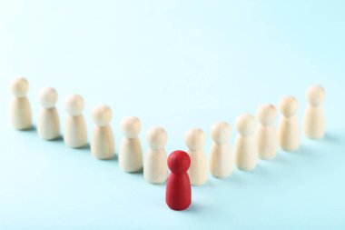 Lider konsepti. Mavi arkaplanda tahta figürler