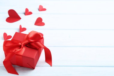 Ahşap masa üzerinde kurdele yay ve kağıt kalpler ile Hediye kutusu