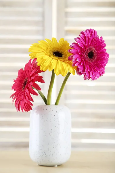 Ceramic vase with gerbera flowers on wooden background — Stock Photo, Image