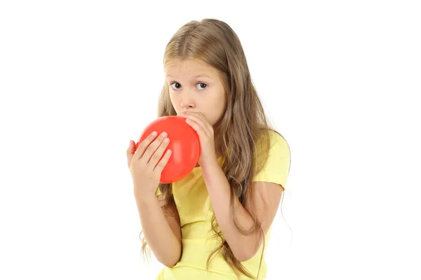 Pretty little girl dmuchanie czerwony balon na białym tle — Zdjęcie stockowe