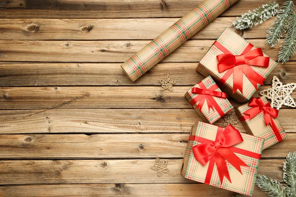 Geschenkboxen mit Ornamenten und Tannenzweigen auf braunem Holz — Stockfoto
