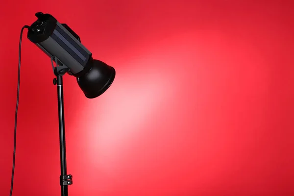 Studio belysning med stativ på röd bakgrund — Stockfoto