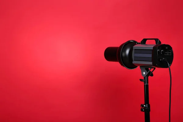 Illuminazione da studio con treppiede su sfondo rosso — Foto Stock