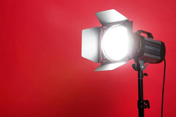 Illuminazione da studio con treppiede su sfondo rosso — Foto Stock