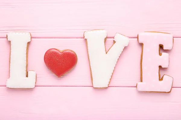 Palavra Amor por biscoitos na mesa de madeira rosa — Fotografia de Stock