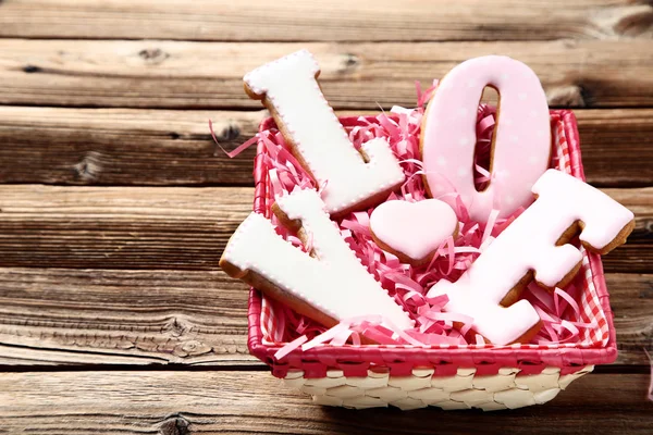 Palabra Amor por galletas y corazón en caja sobre mesa de madera marrón — Foto de Stock