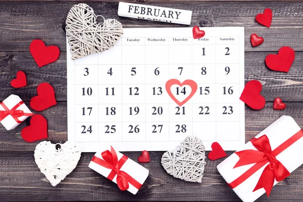 Calendario de San Valentín con corazones coloridos y cajas de regalo en wo — Foto de Stock