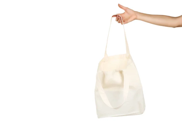 Γυναικείο χέρι που κρατά λευκό βαμβάκι eco bag σε λευκό φόντο — Φωτογραφία Αρχείου