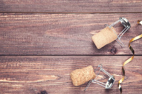 Weinkorken mit Metallkappen und goldenem Band auf brauner Holzlasche — Stockfoto