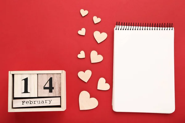 Dia dos namorados em blocos de madeira com corações e bloco de notas — Fotografia de Stock