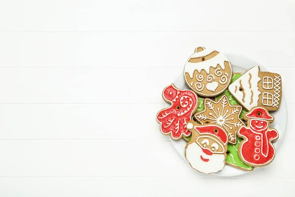 Biscoitos de gengibre de Natal em placa na mesa de madeira branca — Fotografia de Stock