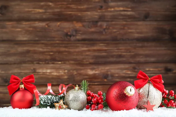 Weihnachtskugeln mit Tannenzweigen und roten Beeren auf braun — Stockfoto