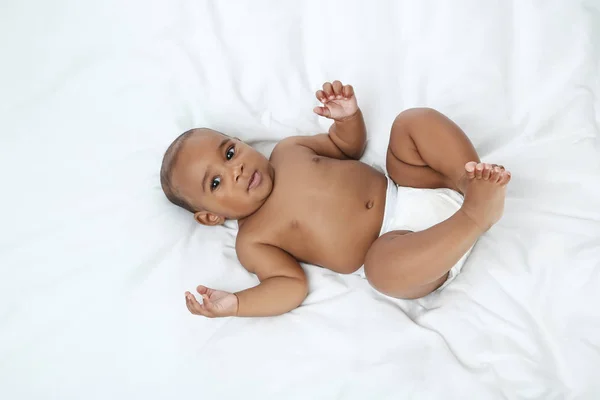 Americano bambina sdraiata sul letto bianco — Foto Stock