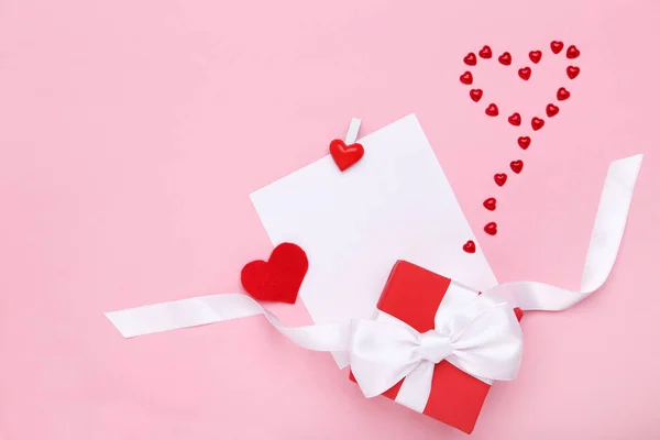 Hoja de papel en blanco con caja de regalo y corazones rojos sobre fondo rosa — Foto de Stock