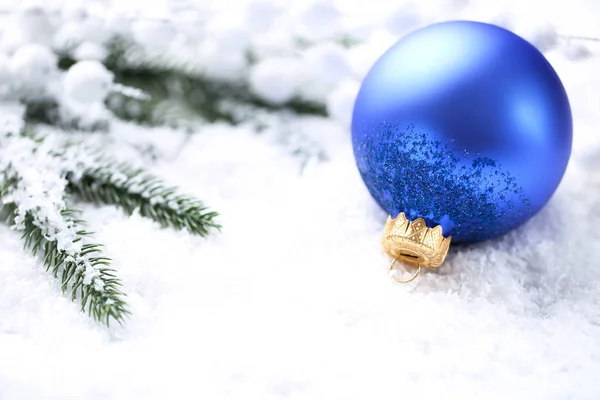 Christmas bauble with fir tree branches on white snow Stock Photo