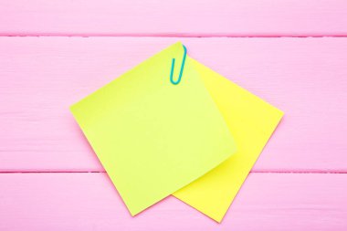 Kağıt yapışkan notlar pembe ahşap masa üzerinde