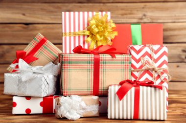 Kahverengi ahşap masada kurdeleli hediye kutuları.